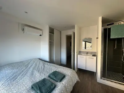 a bedroom with a bed with two towels on it at L'Olivier - Joli duplex au cœur du centre ville à 2 pas de la Rotonde Mirabeau et des allées Provençales in Aix-en-Provence