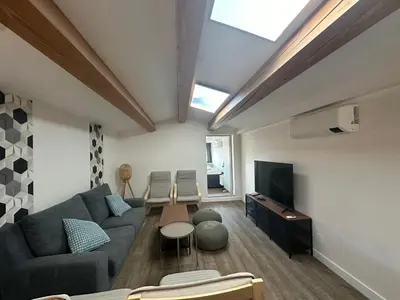a living room with a couch and a tv at L'Olivier - Joli duplex au cœur du centre ville à 2 pas de la Rotonde Mirabeau et des allées Provençales in Aix-en-Provence