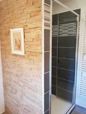 a bathroom with a stone wall and a shower at Maison en Luberon in Sainte-Croix-à-Lauze