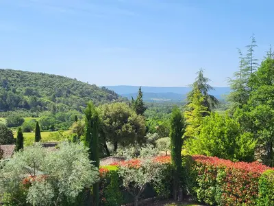 a view of a garden with flowers and trees at L'escapade provençale in Lioux