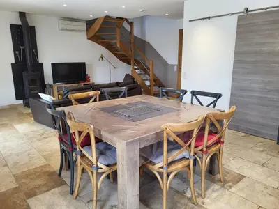 a dining room with a wooden table and chairs at L'escapade provençale in Lioux