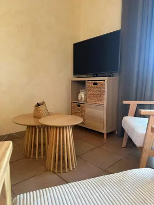 a living room with two tables and a flat screen tv at Bastidon de Gordes in Gordes