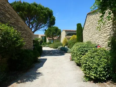 a walkway between two buildings with trees and bushes at Bastidon de Gordes in Gordes