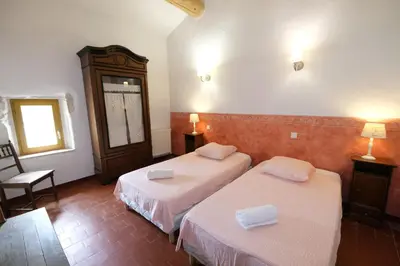 a hotel room with two beds and a chair at Authentique mas avec vue et piscine Eygalieres LS1-447 in Eygalières