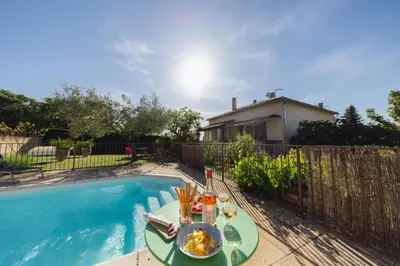 a table with food on it next to a swimming pool at Villa en Luberon, climatisé, Piscine, wifi et Parking gratuit in Bonnieux