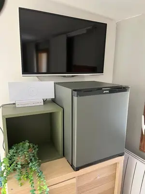 a flat screen tv on top of a refrigerator at Cocon Authentique de Roussillon in Roussillon