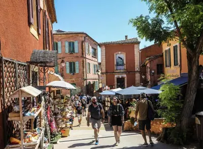 a group of people walking down a street with umbrellas at Cocon Authentique de Roussillon in Roussillon