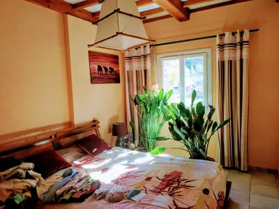 a bedroom with a bed and a large window at Au Bonheur et Liberté in Meyrargues