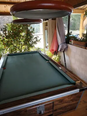 a green pool table in a room with avertisement at Au Bonheur et Liberté in Meyrargues