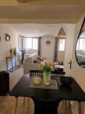 a living room with a table and a couch at Joli Appart Climatisé Hyper Calme Quartier Mairie in Aix-en-Provence
