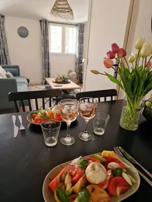 a table with two plates of food and glasses of wine at Joli Appart Climatisé Hyper Calme Quartier Mairie in Aix-en-Provence