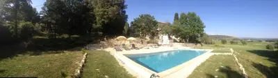 a swimming pool in a field next to a house at Mas de Regardebon in Mazan