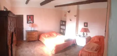 a bedroom with a bed and a dresser and a bed and a bedskirts at Mas de Regardebon in Mazan