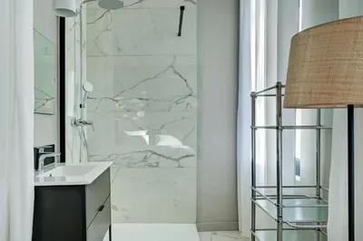 a bathroom with a marble shower with a sink at Hôtel Bellegarde by Viktor in Aix-en-Provence
