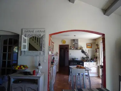 a kitchen with an archway leading to a kitchen with white cabinets at Villa Provençale climatisée près Aix en Provence Piscine securisée alarme in Ventabren