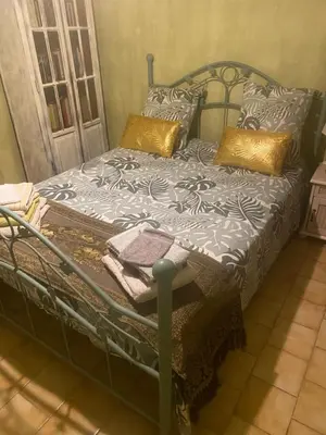 a bed with a metal frame and pillows on it at Villa Provençale climatisée près Aix en Provence Piscine securisée alarme in Ventabren