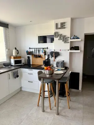a kitchen with a table with a bowl of fruit on it at Le Gîte in Venelles