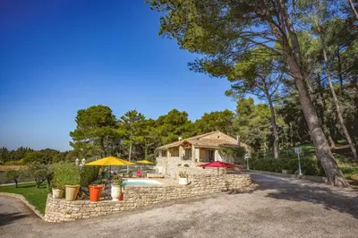 a house with a stone wall and a pool at Villa Cheval Blanc by Villa Plus in Cheval-Blanc