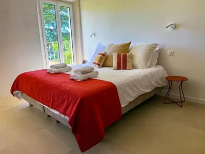 a bedroom with a bed with a red blanket and a window at La Magnanerie 1818 villa de prestige 5 étoiles Luberon in Saint-Saturnin-les-Apt