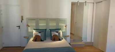 a bedroom with a large bed with blue sheets and pillows at Centre historique studio rénové avec vue in LʼIsle-sur-la-Sorgue