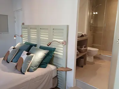 a bedroom with a bed with blue and white pillows at Centre historique studio rénové avec vue in LʼIsle-sur-la-Sorgue