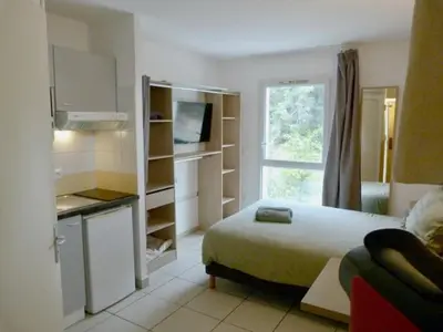 a small room with a bed and a kitchen at Le Clos d'Aix studio 105 parking in Aix-en-Provence