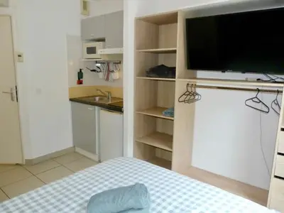 a room with a bed and a tv and a kitchen at Le Clos d'Aix studio 105 parking in Aix-en-Provence