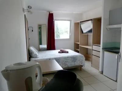 a small room with a bed and a kitchen at Le Clos d'Aix studio 208 parking in Aix-en-Provence