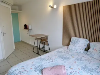 a bedroom with a bed and a table in it at Le Clos d'Aix studio 208 parking in Aix-en-Provence
