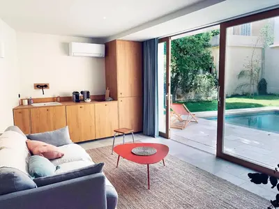 a living room with a couch and a table and a pool at Studio with garden and pool in Aix-en-Provence
