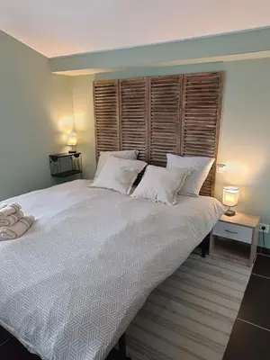 a bedroom with a large bed with white sheets and pillows at Gîte à la ferme in Sénas