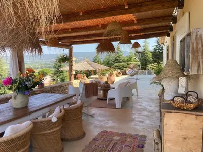 a patio with a table and chairs and a view at La Balinaise in Apt