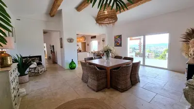 a living room with a wooden table and chairs at La Balinaise in Apt