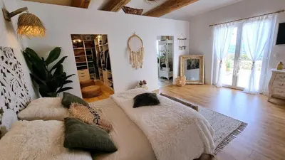 a large bedroom with a bed and a mirror at La Balinaise in Apt