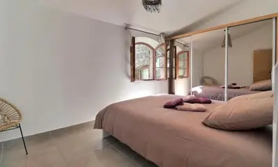 a bedroom with two beds and a mirror at Noceta in Miramas