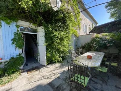 a patio with a table and chairs next to a building at Le 140 du Ventoux in Saint-Saturnin-lès-Avignon