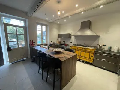 a kitchen with a table and some chairs in it at Le 140 du Ventoux in Saint-Saturnin-lès-Avignon
