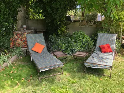 two chairs with pillows sitting in a yard at Le 140 du Ventoux in Saint-Saturnin-lès-Avignon