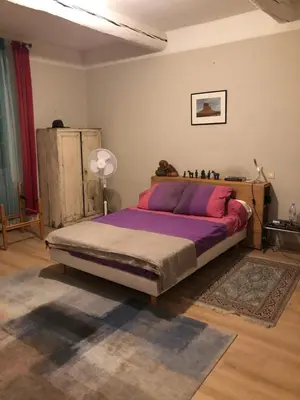 a bedroom with a large bed with purple sheets at Le 140 du Ventoux in Saint-Saturnin-lès-Avignon