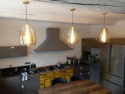 a kitchen with a stove and three lights at Le 140 du Ventoux in Saint-Saturnin-lès-Avignon