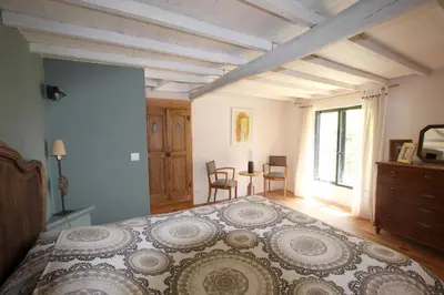 a bedroom with a large bed and a table at La ferme du Loup in Cucuron