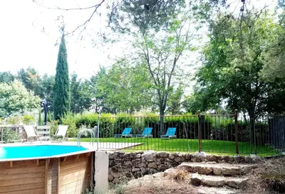 a fence around a swimming pool in a yard at La ferme du Loup in Cucuron