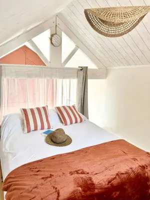 a bed with two pillows and a hat on it at La maisonnette de Tom in Caumont-sur-Durance