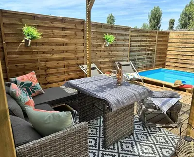a patio with a table and chairs next to a swimming pool at La maisonnette de Tom in Caumont-sur-Durance