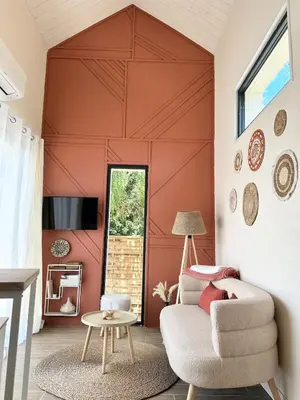 a living room with a red wall at La maisonnette de Tom in Caumont-sur-Durance