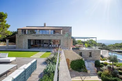 a brick house with a patio and a garden at 8-bedroom luxury villa with pool in Gordes