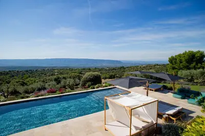 a swimming pool with a view of the mountains at 8-bedroom luxury villa with pool in Gordes