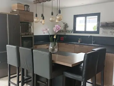 a kitchen with a table with chairs and a vase of flowers at maison en Provence pour un été sous le soleil in LʼIsle-sur-la-Sorgue