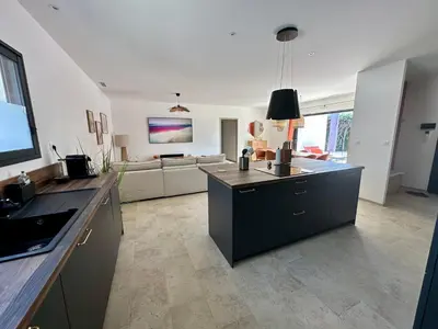 a large kitchen with a living room with a couch at Villa Provençale in Le Thor