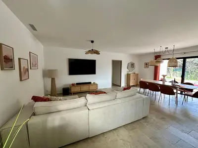 a living room with a white couch and a dining room at Villa Provençale in Le Thor